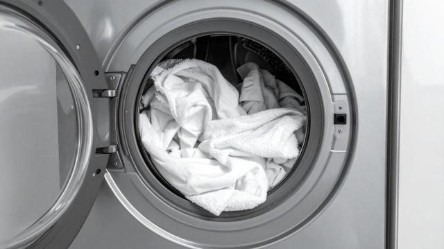 Fresh white towels inside a washing machine drum